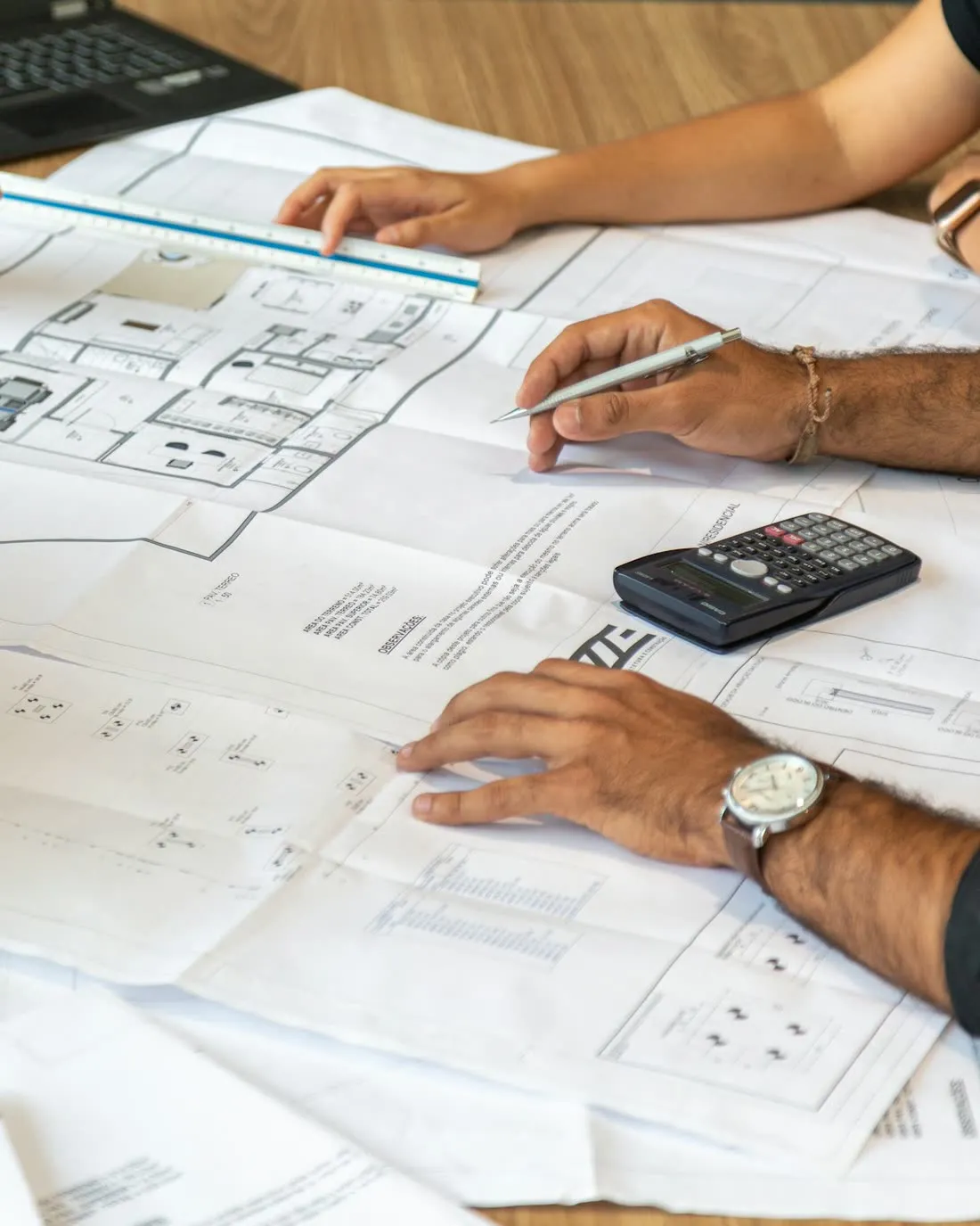 Two people reviewing a home's floor plans together at a table